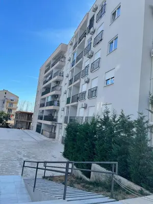 a bench in front of a large building at MBv Budva in Budva