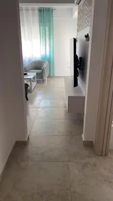 a living room with a couch and a tiled floor at MBv Budva in Budva