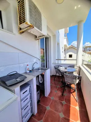 a kitchen with a sink and a table on a balcony at Apartments Yll 3 in Ulcinj
