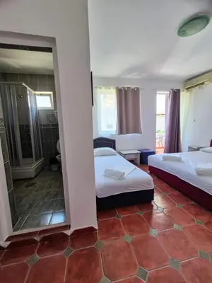 a hotel room with two beds and a mirror at Apartments Yll 3 in Ulcinj