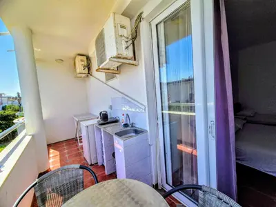 a small kitchen with a sink and a balcony at Apartments Yll 3 in Ulcinj