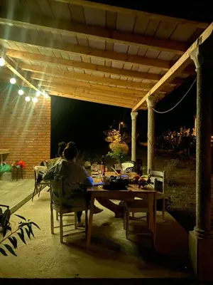 a man sitting at a table under a pergola at Rudinica Baseglamp in Gornji Brčeli