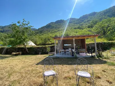 a gazebo with two chairs in a field at Rudinica Baseglamp in Gornji Brčeli