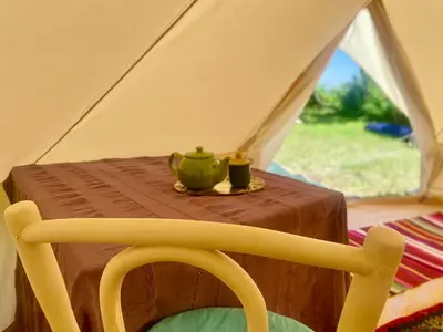 a table in a tent with a tea set on it at Rudinica Baseglamp in Gornji Brčeli