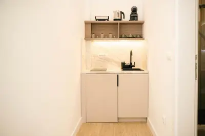 a small kitchen with white cabinets and a sink at Solea Apartments in Ulcinj
