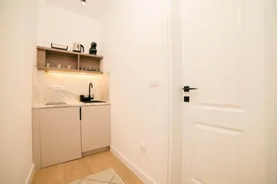 a white kitchen with a door and a counter at Solea Apartments in Ulcinj