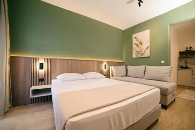 a bedroom with a large bed and a couch at Solea Apartments in Ulcinj