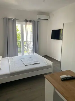 a bedroom with a large bed and a window at Quattro Rocce Apartments Zelen in Sutomore