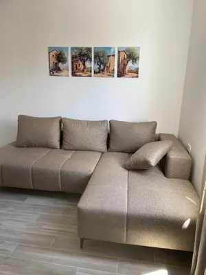 a couch in a living room with four paintings on the wall at Quattro Rocce Apartments Zelen in Sutomore