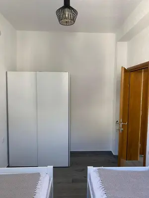 an empty room with two beds and a door at Quattro Rocce Apartments Zelen in Sutomore
