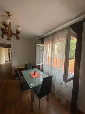 a dining room with a table and chairs and a window at Lana in Cetinje