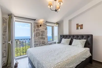 a bedroom with a bed and a large window at Luxury Villa Pjetra