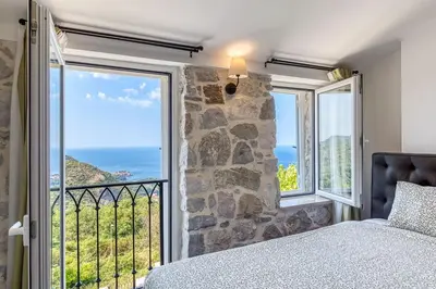 a bedroom with a large window with a view of the ocean at Luxury Villa Pjetra