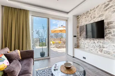 a living room with a couch and a tv at Luxury Villa Pjetra