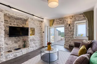 a living room with a stone wall at Luxury Villa Pjetra