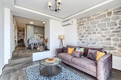 a living room with a couch and a stone wall at Luxury Villa Pjetra