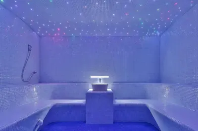 a blue tiled bathroom with a tub and a shower at Hotel Bracera in Budva
