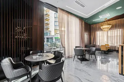 a restaurant with tables and chairs and a large window at Hotel Bracera in Budva