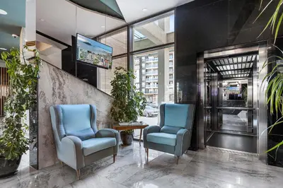 a lobby with two blue chairs and a table at Hotel Bracera in Budva