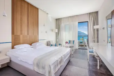 a bedroom with a large bed and a view of the ocean at Hotel Bracera in Budva