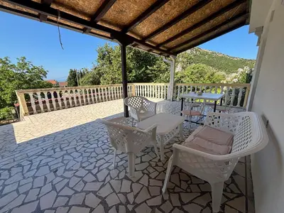a patio with chairs and tables on a stone patio at Vuko i Magdalena Midzor in Petrovac na Moru