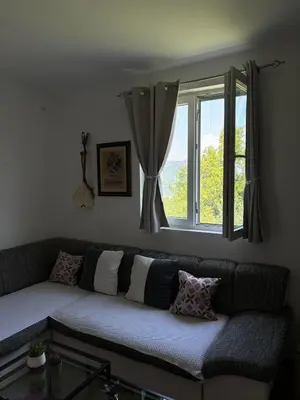 a couch with pillows sitting in front of a window at Deaf Valley Apartment 2 in Reljići