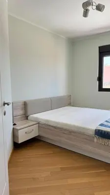 a white bedroom with a bed and a window at One bedroom apartment with sea view Becici in Becici