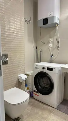 a bathroom with a washing machine and a toilet at One bedroom apartment with sea view Becici in Becici
