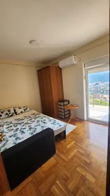 a bedroom with a bed and a large window at Apartman braco in Budva