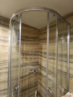 a shower in a bathroom with wooden walls at Martina 1 in Budva