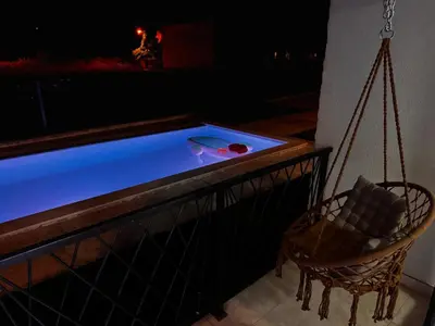 a swimming pool with a swing and a chair at Villa Anastasija in Kotor