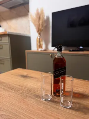a bottle of whiskey and two glasses on a table at Villa Anastasija in Kotor