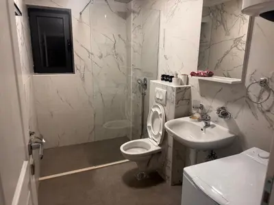 a white bathroom with a toilet and a sink at Villa Anastasija in Kotor