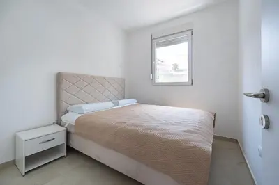 a small bedroom with a bed and a window at OliveRock Apartments - Hladna Uvala in Kruče