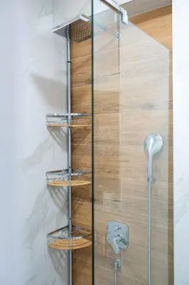 a shower with glass shelves and a wooden wall at OliveRock Apartments - Hladna Uvala in Kruče