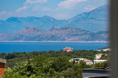 a view of a large body of water and mountains at OliveRock Apartments - Hladna Uvala in Kruče