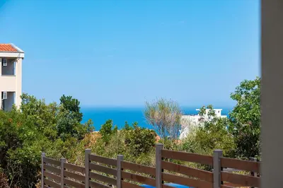a wooden fence with the ocean in the background at OliveRock Apartments - Hladna Uvala in Kruče