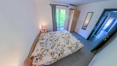 a bedroom with a bed with a floral bedspread at Barona Seaview Penthouse Kotor Bay in Kotor