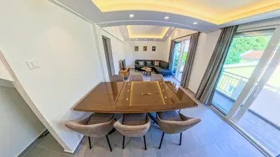 a dining room with a wooden table and chairs at Barona Seaview Penthouse Kotor Bay in Kotor