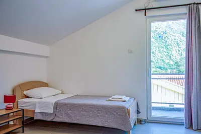 a bedroom with a bed and a large window at Barona Seaview Penthouse Kotor Bay in Kotor