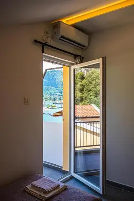 a room with a door open to a balcony with a view at Barona Seaview Penthouse Kotor Bay in Kotor