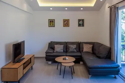a living room with a couch and a table and a tv at Barona Seaview Penthouse Kotor Bay in Kotor