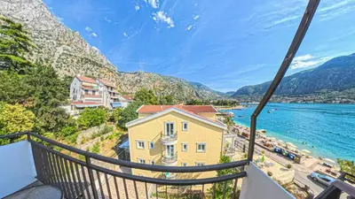 a balcony with a view of a beach and mountains at Barona Seaview Penthouse Kotor Bay in Kotor