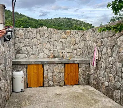 a stone building with a sink and a stone wall at Nina House Charming Apartment, Prevlaka in Prevlaka
