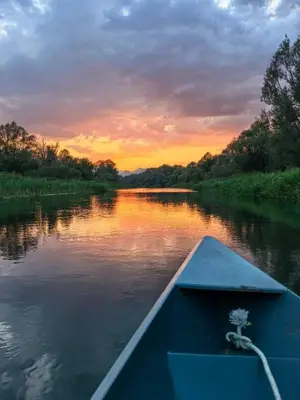a boat on a river with a sunset at Nina House Charming Apartment, Prevlaka in Prevlaka