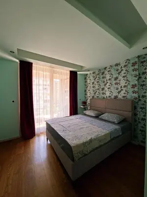 a bedroom with a bed and a large window at Cozy City Center Studio in Babalonija