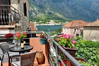 a balcony with a table and chairs and flowers at Apartments Martiva in Kotor