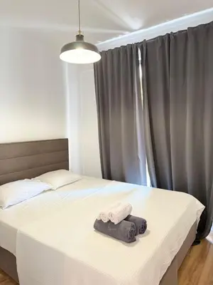 a bedroom with a bed with two towels on it at Apartment with balcony sea view and Parking B12 in Budva