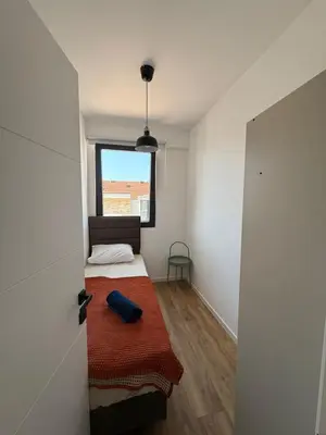 a small bedroom with a bed and a window at Apartment with balcony sea view and Parking B12 in Budva