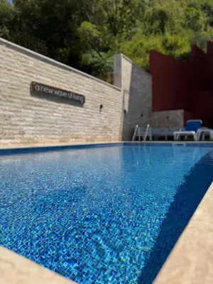 a swimming pool with blue water in front of a building at Apartment with balcony sea view and Parking B12 in Budva